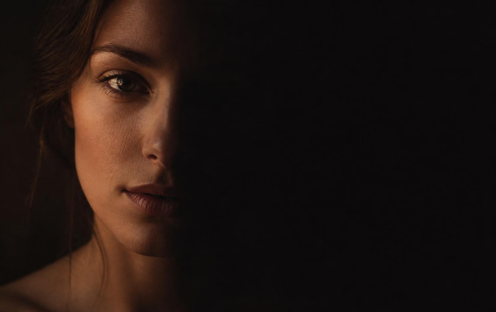 A woman standing quietly in soft golden light, looking calmly toward the horizon — the UNMUTED reconnection journey